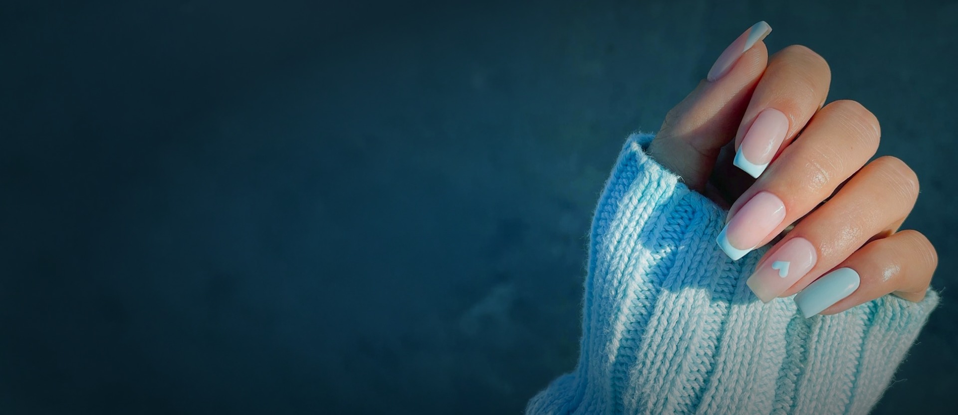 Woman wearing blue jacket showing nails